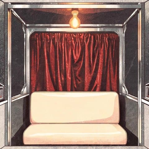 A vintage photo booth interior with a velvet curtain