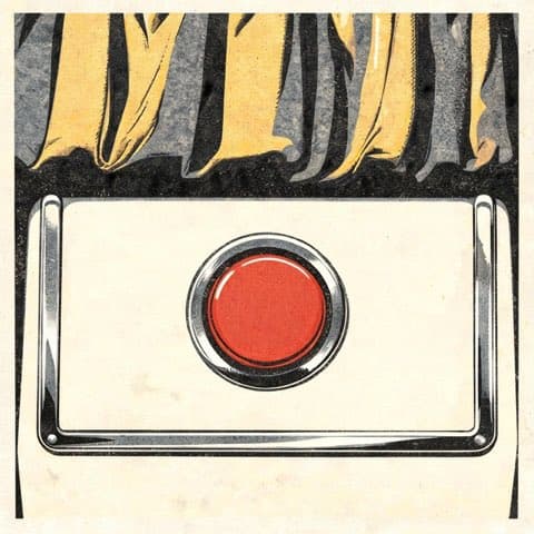 A retro photo booth seat beneath a warm bulb
