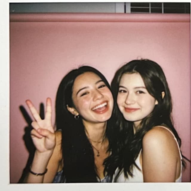 The same two friends, one throwing a peace sign