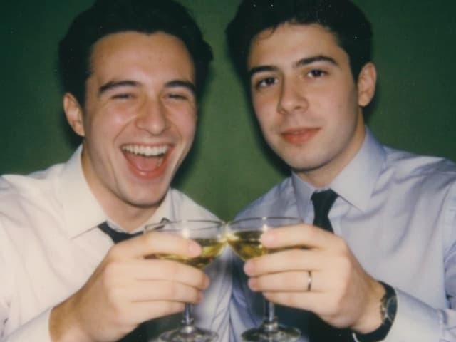 Two friends raising glasses at a celebration